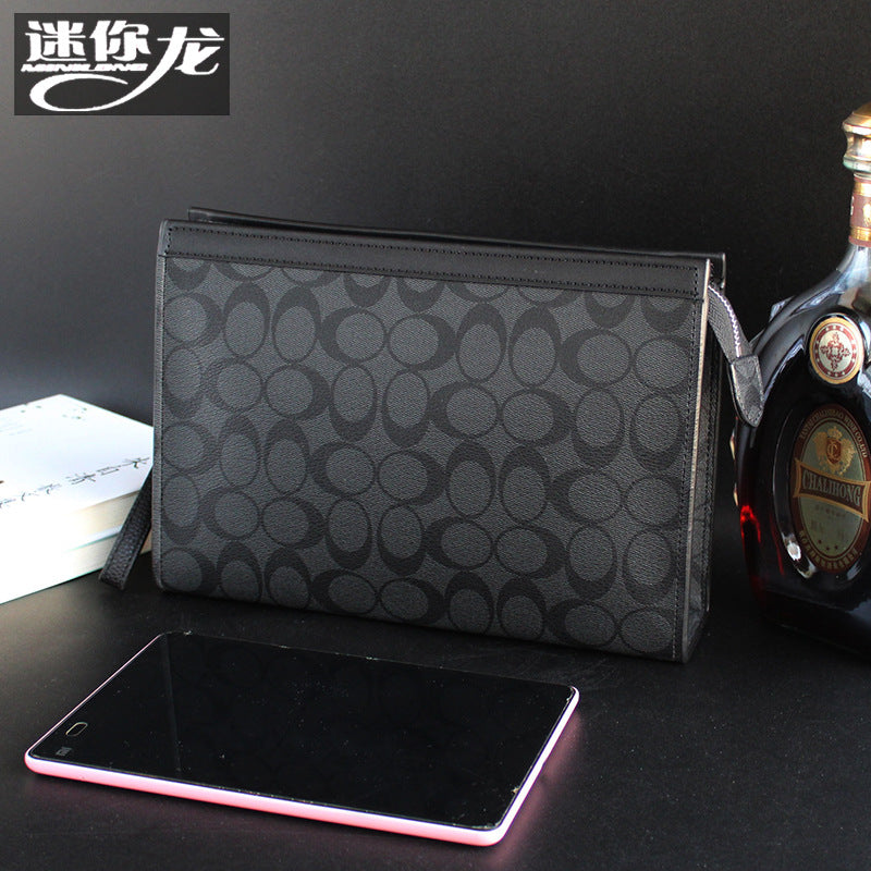 حقيبة يد رجالية من ماركة ميني دراجون (Mini dragon)، وتتميز بهيكلها الجلدي الصلب (Hard Leather Feel) ونقشة المربعات الكلاسيكية (Plaid) الأنيقة، مع شعار حرف الـ "O"