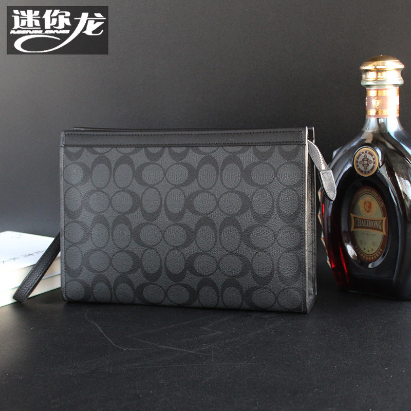 حقيبة يد رجالية من ماركة ميني دراجون (Mini dragon)، وتتميز بهيكلها الجلدي الصلب (Hard Leather Feel) ونقشة المربعات الكلاسيكية (Plaid) الأنيقة، مع شعار حرف الـ "O"