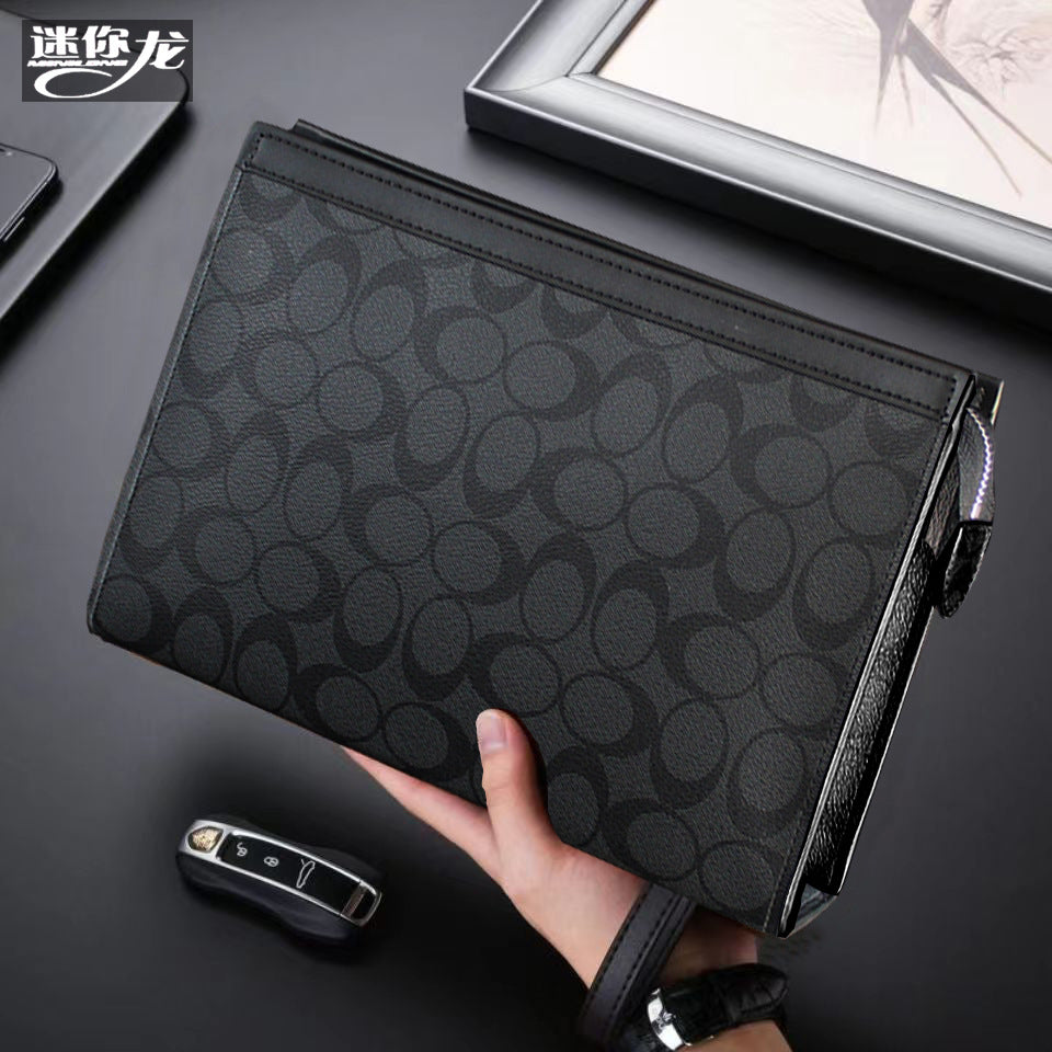 حقيبة يد رجالية من ماركة ميني دراجون (Mini dragon)، وتتميز بهيكلها الجلدي الصلب (Hard Leather Feel) ونقشة المربعات الكلاسيكية (Plaid) الأنيقة، مع شعار حرف الـ "O"