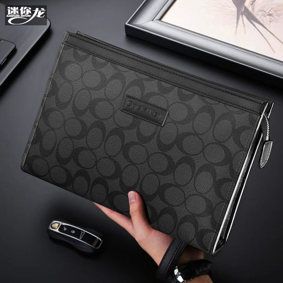 حقيبة يد رجالية من ماركة ميني دراجون (Mini dragon)، وتتميز بهيكلها الجلدي الصلب (Hard Leather Feel) ونقشة المربعات الكلاسيكية (Plaid) الأنيقة، مع شعار حرف الـ "O"